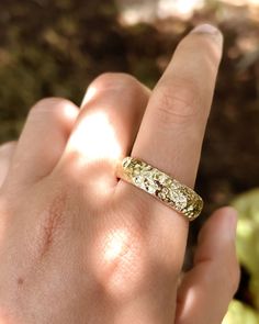 a person's hand with a gold ring on it