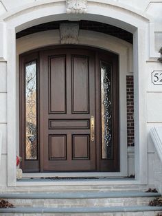 a brown front door on a white house