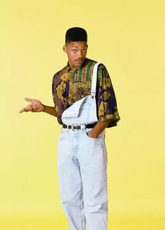 a young man wearing overalls and holding his hand out to the side while standing in front of a yellow background