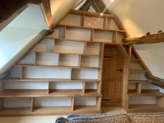 an attic bedroom with built in bookshelves and slanted ceiling, along with a bed