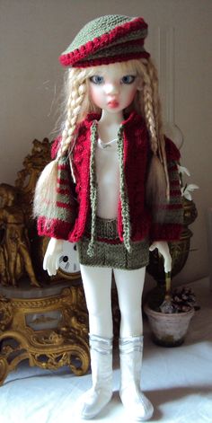 a doll is wearing a knitted hat and jacket