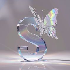 a shiny glass number six with a butterfly on it's back and the letter s in the middle