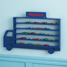 a blue toy car rack with cars on it and the name mattiew in red