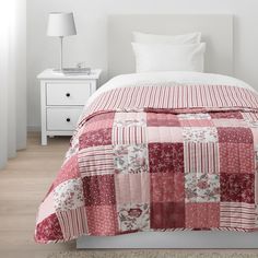 a bed with a red and white quilt on it