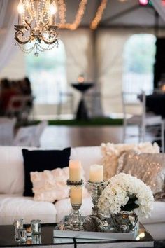 an image of a living room with candles and flowers on the coffee table in front of it