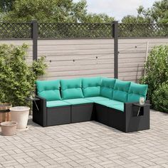 a black and turquoise couch sitting on top of a brick patio