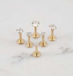 five pairs of gold plated studs with clear crystal stones on each one side