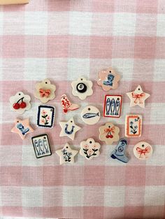 several different types of buttons on a pink and white checkered table cloth