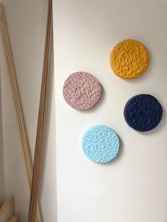 three different colored circles on a white wall next to chopsticks and an object