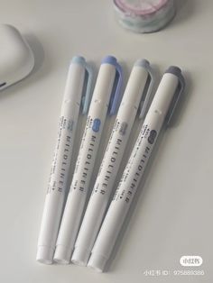 four pens sitting next to each other on a table