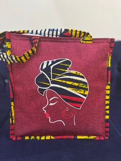 Made by Africa's finest, the cutest most durable tote bag with African print embellishment and embroidery. Whwt makes this bag unique is the fact that this bag is furnished with embroidered images of African beautiful women and embellished with strong vibrant African Print Fabric. This cotton vibrant African Fabric is also used around the rest of the bag which includes the handles.  This tote bag can be used for every day use, to the beach, to lectures, brunch afternoons, church, work. It can fi Red Square Canvas Bag With Large Capacity, Large Capacity Red Square Canvas Bag, Fabric Canvas Bag For Shopping, Red Fabric Shoulder Bag For Shopping, Square Large Capacity Lunch Bag For Gift, Gift Large Capacity Square Lunch Bag, Red Canvas Shoulder Bag For Gifts, Red Fabric Shoulder Bag For Daily Use, Large Capacity Fabric Bags