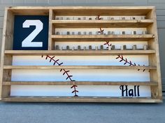 a wooden shelf with baseballs and numbers on the front, along with letters that spell out'2 '