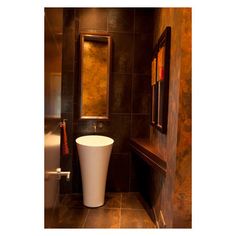 a bathroom with a toilet, sink and mirror on the wall next to tiled walls