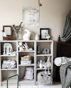 a white shelf filled with stuffed animals and toys