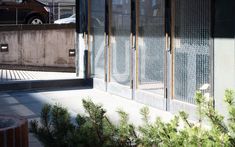 an empty building with glass doors on the outside and cars parked in the street behind it