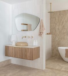 a bathroom with a sink, mirror and bathtub next to a wall mounted toilet