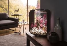 a living room with a fish tank on top of a table next to a couch