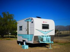 an old camper sits in the middle of a parking lot