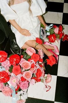 a woman sitting on the floor next to flowers