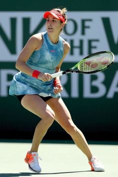 a female tennis player in action on the court with her racket and headband