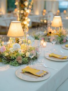 the table is set with flowers and candles