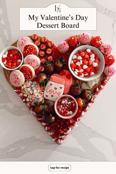 a valentine's day dessert board is displayed in the shape of a heart