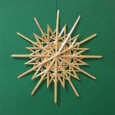 a star made out of toothpicks on a green surface