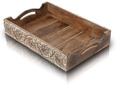 a wooden tray with handles and carvings on the sides, set against a white background