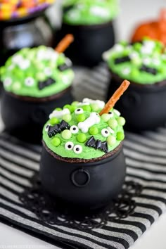 halloween treats in black bowls with green and white decorations on the top, including candy eyes