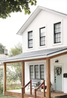 a white house with black windows and a porch