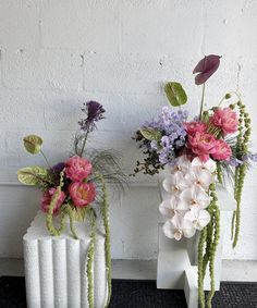 two white vases with flowers in them