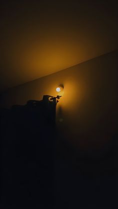 a dark room with a lamp on the wall