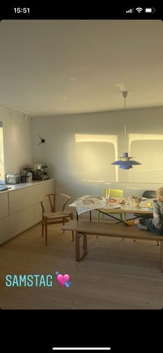 a person sitting at a table in a room with light coming through the windows and floor