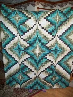 a blue and white quilt hanging on a wall