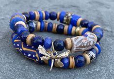 Boho Dragonfly bracelet; Lapis; Blue Jade; African Krobo beads,; Ashanti glass beads; Brass; wood; Bronze; Stacking bracelet; Boho; Tribal Price is for both the bracelets combined. This beautiful boho bracelet set is made of Lapis, Jade, African Krobo beads, Ashanti glass baeds, wood and Brass beads.  Nepali beads adorn one of the bracelets. Artisan Dragon fly charm accentuates the other. Bracelet is  7 inches and fits 5 and half to  6 and a half inch wrist. Please convo with me if you need it bigger. Please Note: I do my best to capture colors accurately on camera, however due to lighting and screen settings, colors may vary in person. Boho Bracelets Stack, Krobo Beads, Bronze Bracelet, Dragonfly Bracelet, Bracelets Boho, Blue Jade, Brass Wood, Lapis Blue, Brass Beads