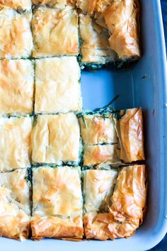 there is a blue dish with some food in it on the table and one has been cut into squares