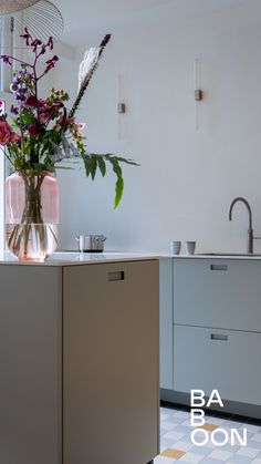 a vase filled with flowers sitting on top of a kitchen counter