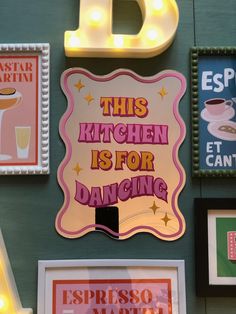 this kitchen is for dancing with neon signs on the wall above it and framed pictures below