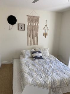 a bedroom with a bed, ceiling fan and pictures hanging on the wall above it