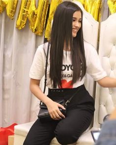 a woman sitting on top of a white chair