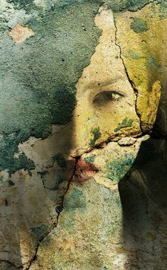 a woman's face is painted on the side of a wall with peeling paint