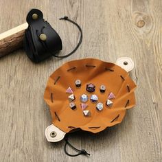 an orange paper plate sitting on top of a wooden table next to a black bag