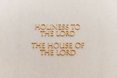 the word holness to the lord is etched in gold on a white wall