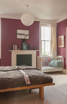 a bedroom with purple walls and a white fireplace