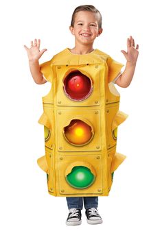 a young boy wearing a yellow traffic light costume with his hands in the air and smiling