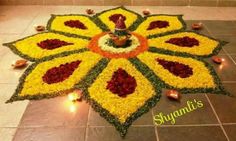 a decorated flower arrangement with candles on the ground in front of a tile floor that reads happy diwali