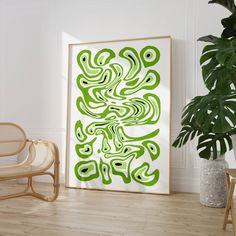 a green and white abstract painting on a wall next to a chair in a room