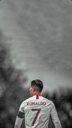 a soccer player in white and red is looking up at the sky with his head down