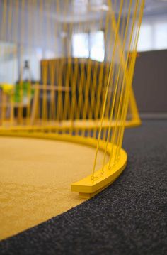 a yellow object sitting on top of a carpeted floor next to a chair and table