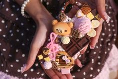 a woman's hands holding an assortment of miniature food items in the shape of teddy bears